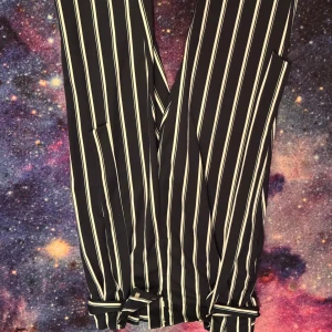 Svartvita randiga byxor - Snygga svartvita randiga byxor med. Byxorna har en rak passform. Använt en gång.