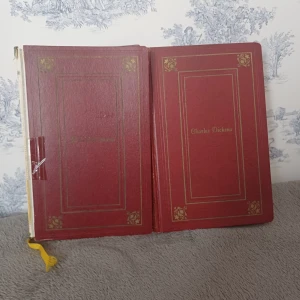 Oliver Twist av Charles Dickens - Säljer en klassisk bok, 'Oliver Twist' av Charles Dickens. Boken har en röd hårdpärm med guldtryck och dekorativa detaljer. Perfekt för samlare eller litteraturälskare!