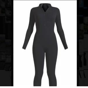 Svart långärmad jumpsuit med dragkedja Pretty Little Thing - Säljer en svart, tight långärmad jumpsuit med dragkedja framtill. Perfekt för dig som vill ha en stilren och enkel look. Hög krage och figurnära passform ger en snygg siluett.