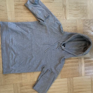 Grå J.Lindberg hoodie - Säljer en grå J.Lindberg hoodie som knappt är använda. Skicket är som nytt och tröjan är i storlek S. Skriv vid funderingar!