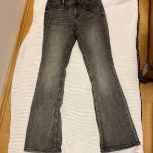 Grå bootcut jeans från Touch L/32 - Snygga grå jeans från Touch med bootcut passform. Jeansen har klassisk femficksdesign, normalhög midja och är tillverkade i denim. Perfekta för dig som vill ha en avslappnad men trendig look.