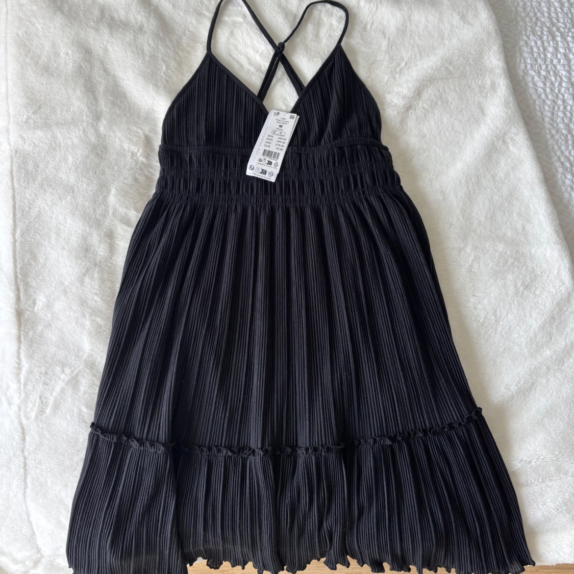 Plisserad svart klänning med smala axelband