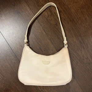 Axelväska - Säljer en snygg beige väska med justerbart axelband. 