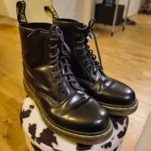 Svarta Dr. Martens boots 42 - Säljer ett par Dr. Martens boots som enbart legat o samlat damm hemma. Obs! Ej läder utan mer utav fejkläder/"plast-läder". Som nya, både sko och sula! 