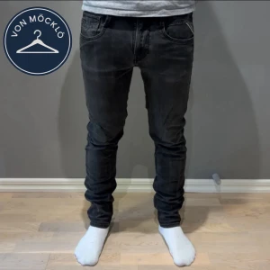 Svarta Replay Anbass jeans - Säljer ett par svarta Replay Anbass jeans med slim passform. Jeansen har klassisk femficksdesign, dragkedjegylf och diskret Replay-logga vid fickan. Perfekta för dig som gillar en modern och stilren look. W30 L32🤗