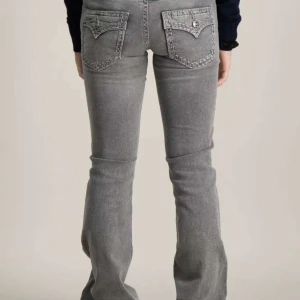 Grå bootcut jeans med broderade bakfickor - Snygga grå jeans med bootcut passform och broderade detaljer på bakfickorna. Knappt använda, är i väldigt bra skick 