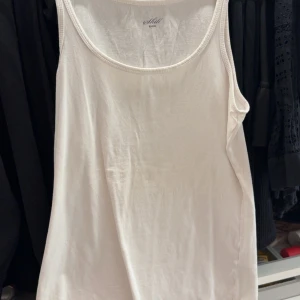 Vit linnetopp från Still - En klassisk vit linnetopp från Still. Perfekt att bära som den är eller under en skjorta. Enkel och stilren design med rund halsringning och breda axelband.