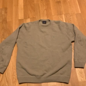 Beige stickad tröja från Boomerang - Säljer en stilren beige stickad tröja från Boomerang i storlek m/L. Tröjan har rund halsringning, långa ärmar och en liten broderad detalj på bröstet. Perfekt för lager-på-lager under kyliga dagar.