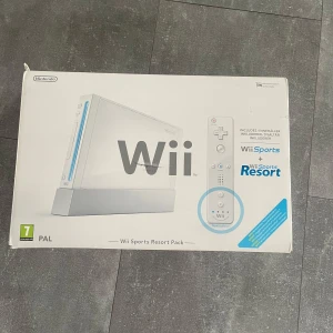 Nintendo Wii Sports Resort Pack - Nintendo Wii Sports Resort Pack med originalkartong. Inkluderar vit Wii-konsol, Wii Remote, nunchuk, kablar och manual. Spelen Wii Sports och Wii Sports Resort medföljer. Perfekt för spelkvällar med vänner eller familj.