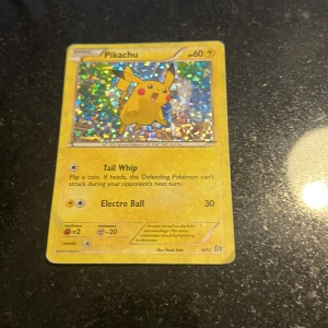 Pikachu - Det här är ett glittrande samlarkort med Pikachu från Pokémon. Perfekt för dig som gillar att samla, spela eller bara vill ha en ikonisk figur i din samling. Kortet har färgglad design och är en favorit bland både unga och vuxna Pokémon-fans.
