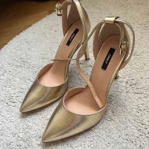 Guld Klackskor från Only - Guld klackskor från Only i storlek 39, aldrig använda💗 Ungefär 10cm klackhöjd. Skorna har lite padding i sulan vilket gör dem bekvämare och lättare att gå i