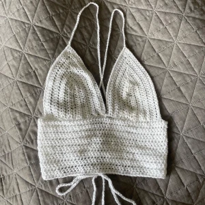 Handvirkad topp - Säljer en handvirkad vit topp jag själv gjort. Den har smala axelband och snörning i ryggen och tack vare den reglerbara knytningen passar den många olika storlekar! 