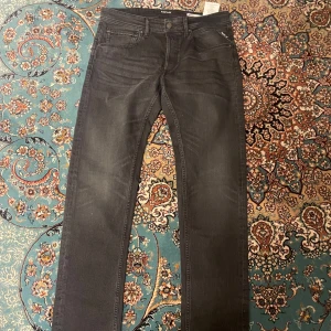 Replay Jeans Grover Svarta - Säljer ett par svarta Replay Grover jeans i storlek 32. Klassisk femficksmodell med raka ben och diskreta slitningar. Jeansen har knappgylf och är tillverkade i ett mjukt denimtyg som sitter skönt hela dagen.