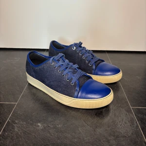 Lanvins - Snygga och sparsamt använda sneakers från Lanvin. Mörkblåa med strukturmönster och detaljer i slätt läder. I bra skick med lätt slitage på lädret. Hör av dig vid intresse! 🙌
