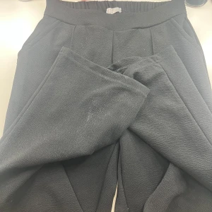 Svarta mjukisbyxor från H&M - Svarta mjukisbyxor med bred resår i midjan och raka ben. Byxorna är tillverkade i ett mjukt och bekvämt material, perfekta för en avslappnad stil. Fickor på sidorna och enkel design.