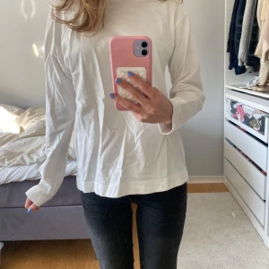 Vit långärmad tröja från Zara - Säljer en enkel och stilren vit långärmad tröja från Zara. Tröjan har en rak passform och är tillverkad i mjukt bomullsmaterial, perfekt för en clean och avslappnad look.