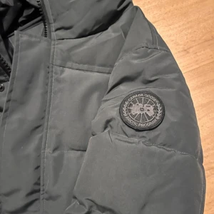 Äkta grå Canada Goose jacka - Säljer en grå vinter jacka från Canada Goose med huva och diskret logotyp på ärmen. Jackan har dragkedja, knappar och två stora fickor framtill. Perfekt för kalla dagar och riktigt varm.köppt för 9000kr, säljer billigt för behöve pregnant för en sommar jacka. Digital kvitto finns så klart