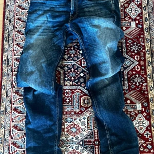 Blå jeansbyxor med raka ben - Najs blåa jeans från Jack & Jones utan någon skada och är i nästintill nyskick med dragkedja gylf