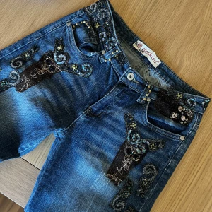 Blå jeans med broderade detaljer  - Coola unika jeans med brodereri och detaljer. Low waist, raka ben, är 165cm! 
