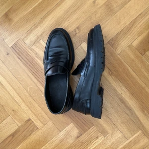 Svart Les Deux Loafers - Ett par klassiska LES DEUX svarta loafers med en robust sula. Perfekt för både vardag och fest.  Storlek 40