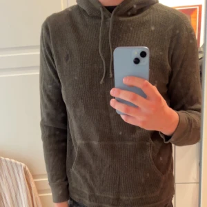 Olivgrön hoodie från Polo Ralph Lauren - Säljer en olivgrön hoodie från Polo Ralph Lauren. Tröjan är ribbstickad med huva och dragsko samt en klassisk känguruficka framtill. Perfekt för en avslappnad och stilren look. Storleken är L men den passar som en M. Priset kan diskuteras vid en snabb affär!