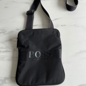 Hugo boss axelväska  - Hej ! säljer denna Hugo boss väska som är i sparsamt skick, självklart äkta, fint skick, vid frågor hör av er!