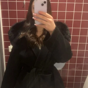 Svart kappa med päls  - Säljer en svart kappa med päls och knytbälte i midjan. Säljer den pågrund av ingen användning, storlek M men passar vem som helst eftersom de är ett band man kan knyta hur mycket man vill, pris kan diskuteras❤️ om att få fler bilder eller frågor skriv till mig❤️
