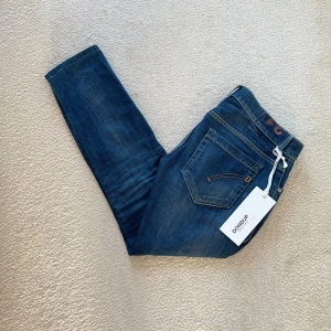 Dondup jeans  - Säljer ett par klassiska blå jeansbyxor från Dondup i modellen George. Byxorna har normal passform. Tillverkade i jeansmaterial med detaljerade sömmar. Perfekta för en stilren look. Byxorna är nästintill nya!!! Hör av er vid minsta fundering😄