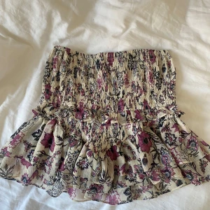 Blommig zara kjol - Blommig kjol från zara som är lite beige/lila/rosa i färgen i storlek xs, stretchigt material