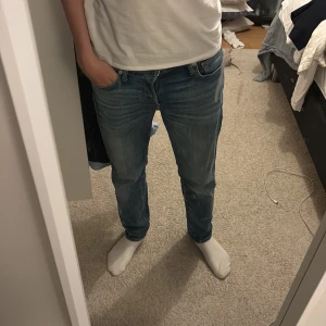 Blå jeans från Jack & Jones - Snygga blå jeans från Jack & Jones med klassisk femficksdesign och en bekväm passform. De har en normal midja och raka ben, vilket gör dem perfekta för en avslappnad stil. Märkeslappen i läder på baksidan ger en extra touch av stil. W28 men passar 29 också!