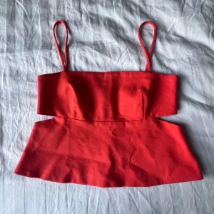 Orange croppad topp från Zara XS - Snygg orange croppad topp från Zara med smala axelband och markerad midja. Toppen har en stilren design med dold dragkedja i ryggen och är perfekt för dig som vill sticka ut. Materialet är mjukt och lätt, vilket gör den bekväm att bära.