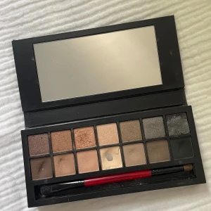 Smashbox ögonskuggspalett - Säljer en Smashbox Full Exposure ögonskuggspalett med 14 nyanser i både matta och skimriga toner. Färgerna går i brunt, beige, guld, grått och svart. Paletten har en stor spegel och medföljer en dubbeländad borste