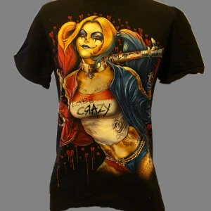 Svart t-shirt med Harley Quinn-tryck - svart t-shirt med Harley Quinn både fram och bak. Märkte att jag aldrig använt den. Den sitter rätt normalt på. Inget speciellt egentlige. Den ä hel oså.