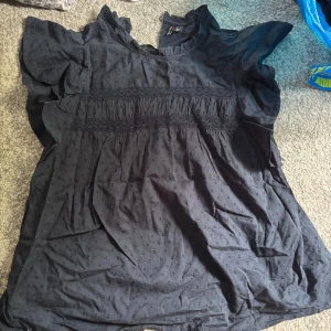 Svart blus med broderade detaljer - Märkblå blus från vila. Med små broderade prickar och voluminösa korta ärmar. Max använd 1-2 gånger