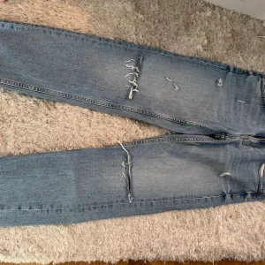 Zara jeans -  ripped jeans  - Säljer ett par ljusblå jeans med slitna detaljer och revor på benen. Endast använda. Storlek 36