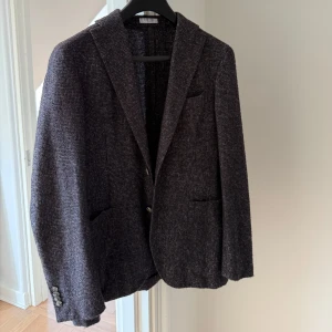 Mörkgrå/brun kavaj från Boglioli Milano - Snygg kavaj från Boglioli Milano med diskret rutig struktur. Väljer att sälja denna stiliga sommar kavaj då den inte passar mig längre. Köpt för två år sedan med ett ny pris 9000kr. Pris kan diskuteras vid snabb affär! 