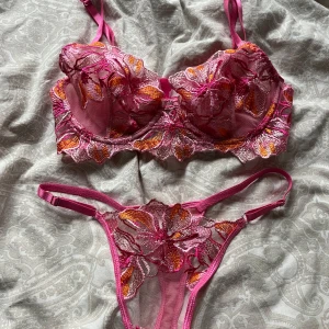Rosa spets-bh och trosa - Säljer ett set med bh och trosa i rosa med broderade blommor. Bh:n har bygel och justerbara axelband. Trosan är högt skuren med matchande broderi. Perfekt för dig som vill ha något extra fint under kläderna.