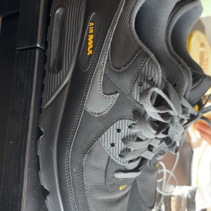 Nike Air Max svarta sneakers - Svarta Nike Air Max sneakers med gula detaljer och klassisk logga. De är slitna på sidan kom pm för bild inte hål.Ovandel i mesh och syntet, robust sula och snörning. Snygg streetstil med diskret gul swoosh och Air Max-tryck på sidan. Perfekta för dig som gillar stilrena och sportiga skor. Princip nya små bara för mig.