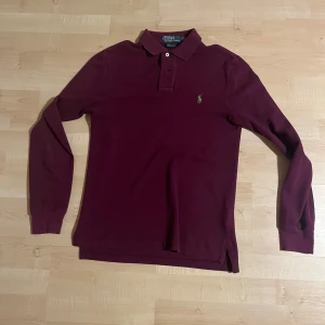 Vinröd långärmad pikétröja Polo Ralph Lauren - Långärmad pikétröja från Ralphlauren i mycket bra skick. Använd någon gång. Slim fit. Pris kan diskuteras