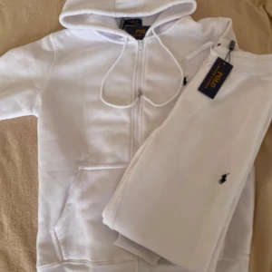 Polo Ralph Lauren set  - Vit set från Polo Ralph Lauren med dragkedja framtill, huva med snörning och två stora fickor. Klassisk broderad logga på bröstet. Stilren look som passar perfekt till chill dagar. Storleken är S men passar rätt bra i M med. Priset kan diskuteras!