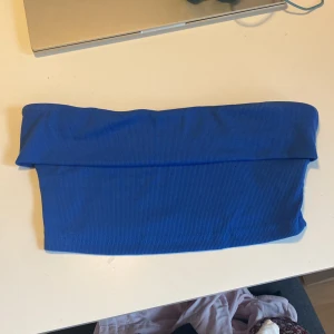 Marinblå tubtopp  - Säljer en blå ribbad tubtopp i storlek S. Toppen är bandeau-modell, ärmlös och har en tight passform. 