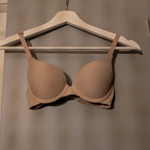Push up bh - En enkel och stilren beige bh med vadderade kupor och justerbara axelband. Perfekt under ljusa toppar för en osynlig look. Mjuk och bekväm med slät yta och klassisk form. Använd max 3 gånger. Pris kan diskuteras.