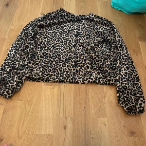 Leopardmönstrad tröja från Lindex - Cool långärmad tröja från Lindex i leopardmönster med beige och svarta toner. Tröjan har en loose passform och är tillverkad i mjukt syntetmaterial. Perfekt för dig som vill sticka ut med ett djurmönster i din outfit.