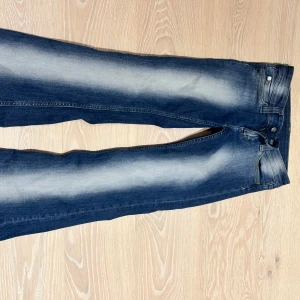 Blå bootcut jeans med slitningar - Weekday jeans som är i storlek 25/30 men då är uppsydda! Nu när de är uppsydda skulle jag säga att de passar som en 152cm storlek!! Snygga blå jeans med bootcut passform och coola slitningar längs benen. Jeansen har klassisk femficksdesign, dragkedja och knapp framtill. 