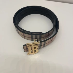 Burberry bälte - Ett reverseble burberry bälte så man kan byta sida på bältet så man har både beige och svart bälte med guldig logga och den är helt ny. Pris kan diskuteras och skriv om du har några frågor. 