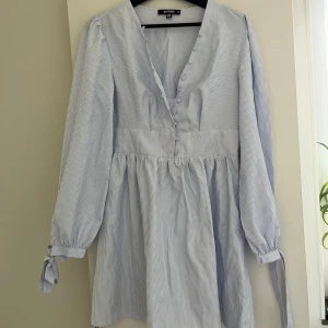 Randig kortklänning från Missguided - Supersöt kortklänning från Missguided i ljusblått och vitt med tunna ränder. 