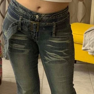 Blå jeans med bälte och flare - Säljer ett par blå jeans med flare och ett matchande bälte med metallspänne. Jeansen har en normal passform och är perfekta för en avslappnad stil. Snygga detaljer och klassisk denim-look. Storlek 28/S. Knappt använda!🦄