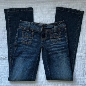 Lågmidjade bootcut jeans - BARA SERIÖSA KÖPARE PLS! Använda ett fåtal gånger men i mycket bra skick. Storlek 3/4 (25/26?). Midjemått 73 cm, grenhöjd 16.5 cm, innerbenslängd 80 cm. Jag är 173 cm för referens. Priset går inte att diskutera. Använd gärna KÖP NU om du vill köpa.