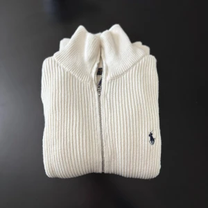 Vit Ralph Lauren tröja - Säljer nu den här Ralph tröjan på grund av att den var lite för stor. Den är sprillans ny och har inte använts. Vid begäran om bilder och frågor så är de bara att skriva ett dm!