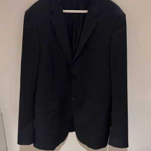 Svart kavaj från Tiger of Sweden - Säljer en klassisk svart kavaj från Tiger of Sweden i storlek 50 i färgen navy blue. Har använt kavajen en gång på ett bröllop för 2 år sedan nu hänger den bara där och är för liten, nypris 3500, kan tänka mig att släppa den för någonstans runt 1000